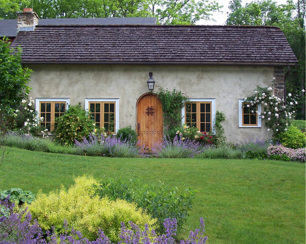 Дом с необычной дверью в окружении цветущего сада