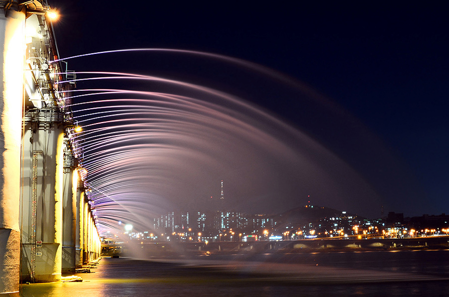 Неоновая подсветка воды фонтана из моста