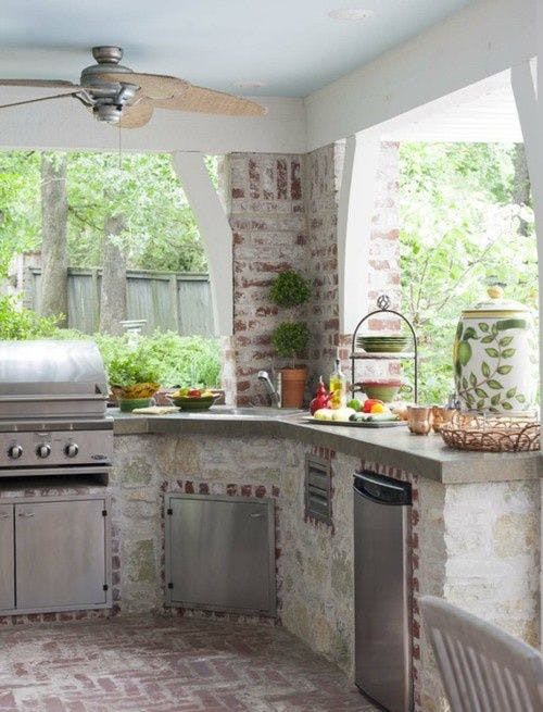 Дизайн светлой летней кухни потолочным вентилятором и декором из живых цветов