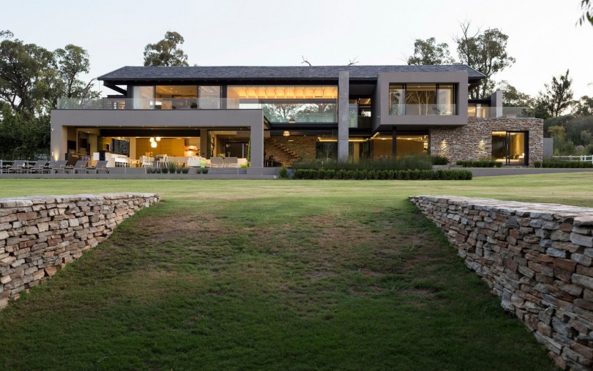 В дизайне дома из бетона и ландшафта используется природный камень
