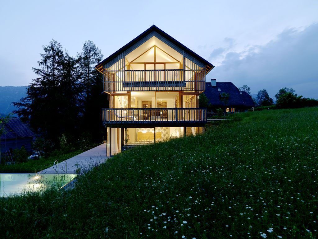 Дом со стеклянным фасадом в Австрии вечером