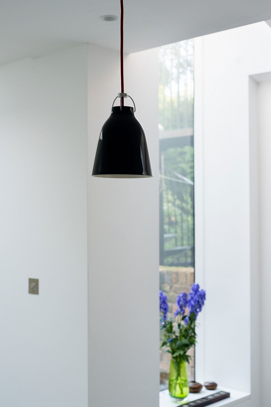 Черный светильник в белом интерьере кухни