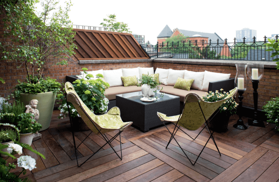Оформление террасы загородного дома на крыше - угловой диван, кресла и цветы