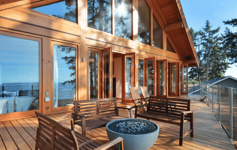 Оформление террасы загородного дома - деревянные скамейки и каменная чаша
