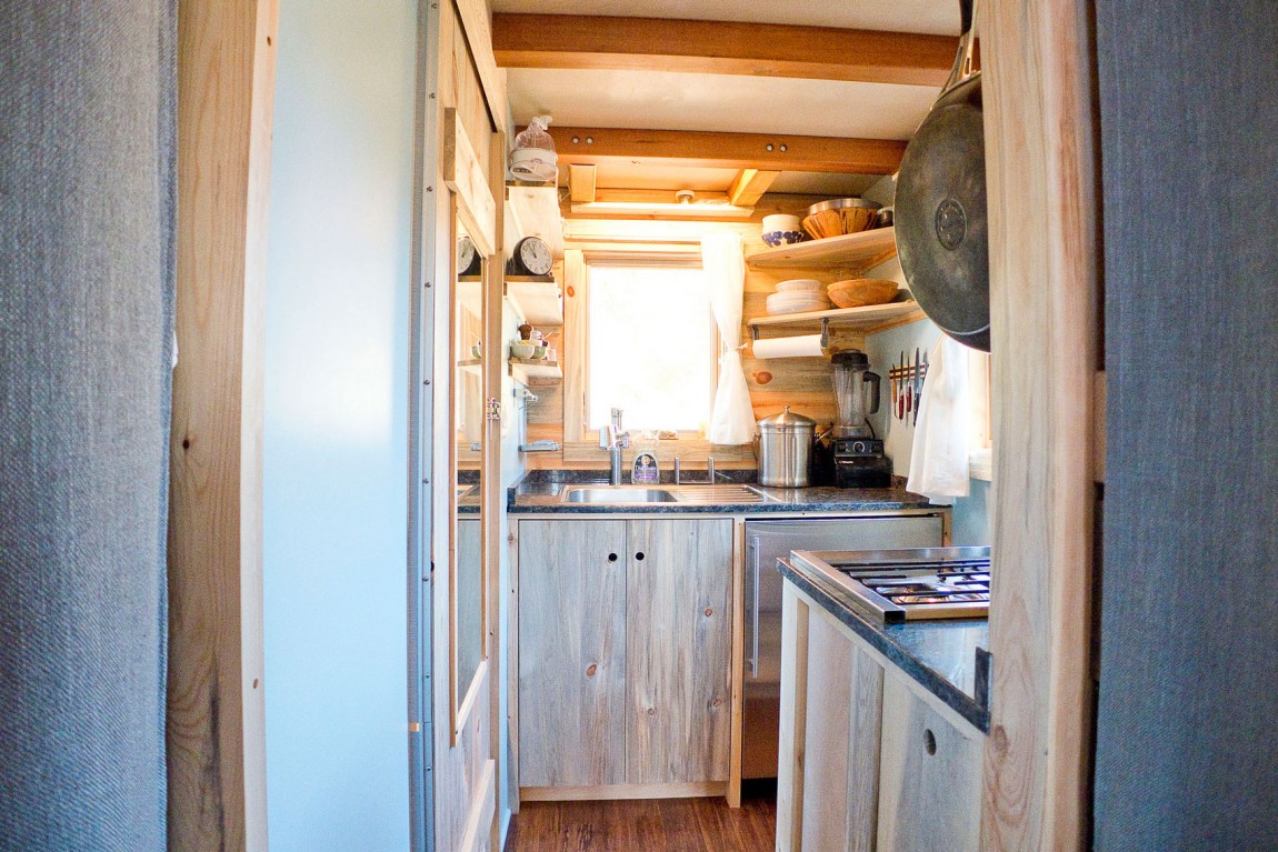 Вид кухни с комнаты в деревянном доме на колесах в штате Айова