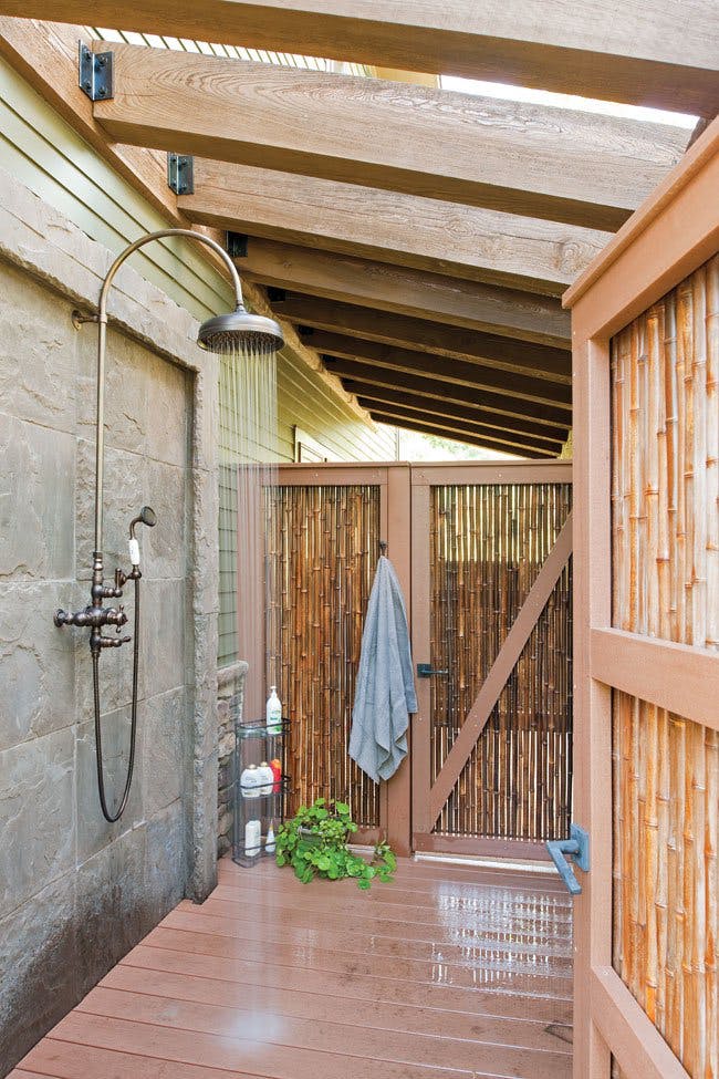 Стены из досок и бамбуковых стеблей примыкающие к дому