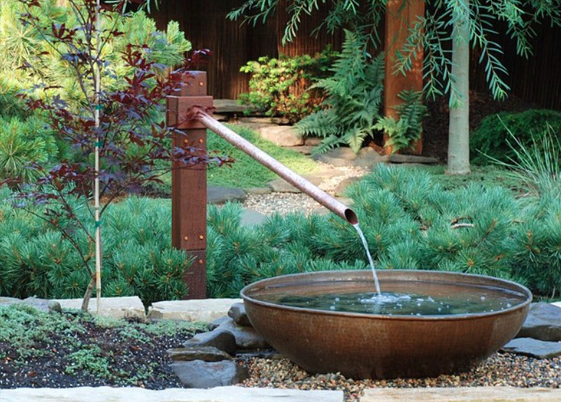 Вариант ландшафтного дизайна загородного дома -  водопад из трубы и железной чаши